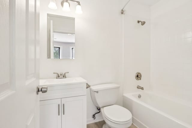 full bathroom featuring tiled shower / bath combo, vanity, and toilet