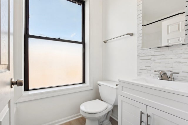 bathroom with vanity, decorative backsplash, and toilet