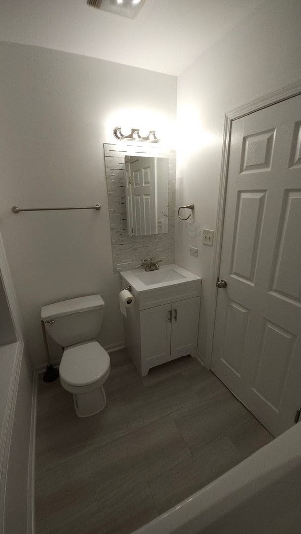 bathroom featuring vanity, toilet, and hardwood / wood-style flooring