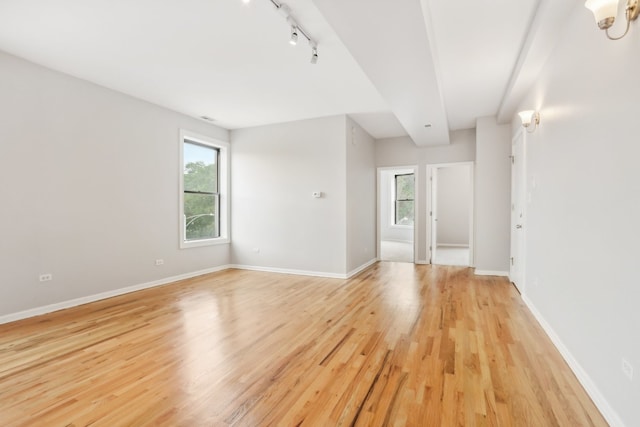 spare room with light hardwood / wood-style flooring and rail lighting