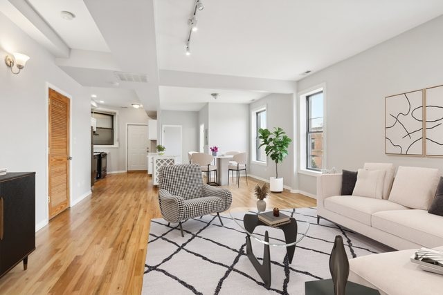 living room with light hardwood / wood-style flooring and rail lighting