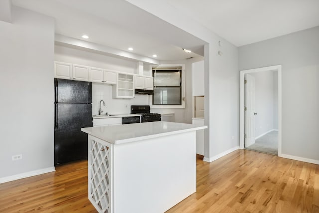 kitchen with black appliances, a center island, sink, and white cabinets