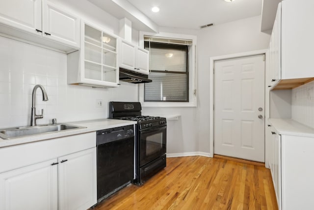 kitchen featuring black appliances, sink, decorative backsplash, light wood-type flooring, and white cabinets