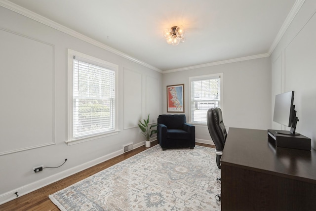 office space featuring crown molding, baseboards, wood finished floors, and visible vents