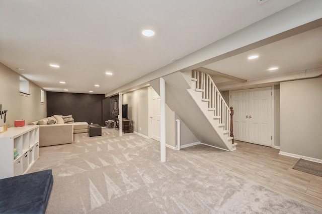 finished below grade area featuring recessed lighting, baseboards, light carpet, and stairway