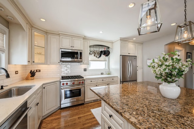 kitchen with a sink, decorative backsplash, stainless steel appliances, and wood finished floors