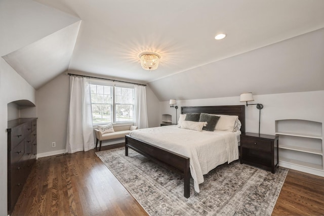 bedroom with baseboards, wood finished floors, and lofted ceiling