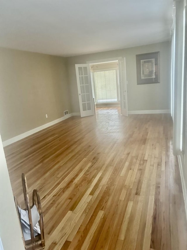 unfurnished room with french doors and light hardwood / wood-style floors