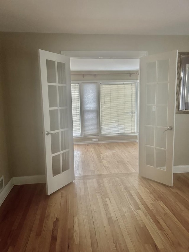 empty room featuring light hardwood / wood-style flooring and french doors