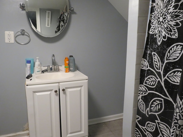 bathroom with vanity, tile patterned floors, and lofted ceiling