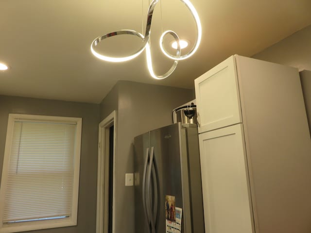 details featuring stainless steel fridge and an inviting chandelier