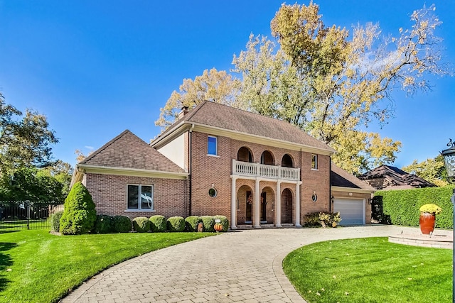 view of front of home featuring a balcony, a front lawn, and a garage