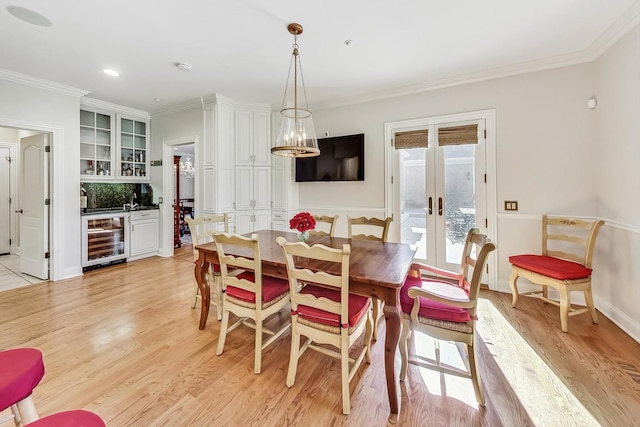 dining room with french doors, wine cooler, crown molding, a chandelier, and light hardwood / wood-style floors