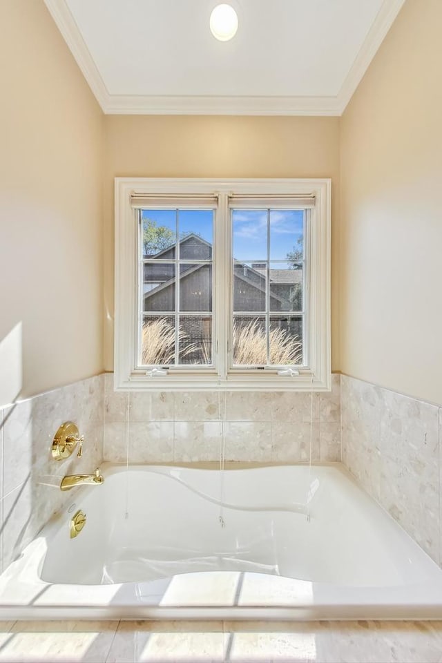 bathroom featuring a relaxing tiled tub, ornamental molding, and a healthy amount of sunlight