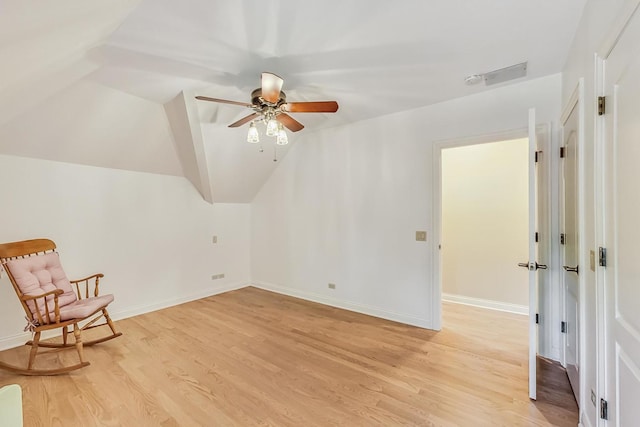 living area with vaulted ceiling, light hardwood / wood-style floors, and ceiling fan