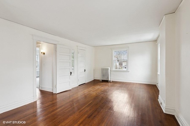 spare room with hardwood / wood-style flooring, baseboards, and radiator