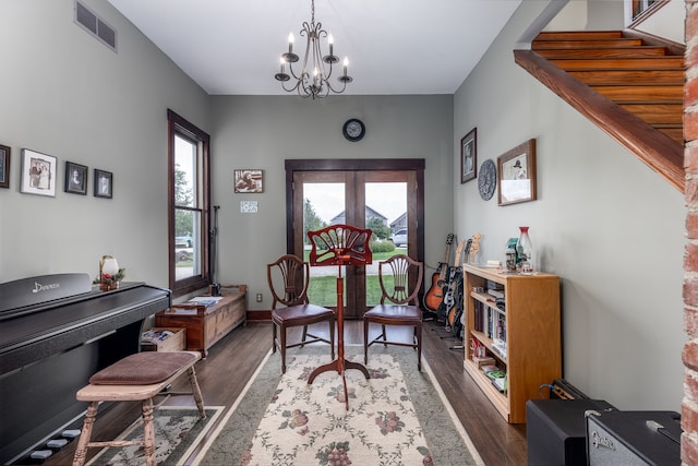 sitting room with dark wood-type flooring, an inviting chandelier, and french doors