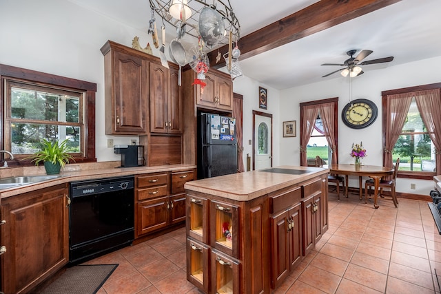 kitchen featuring sink, beam ceiling, black appliances, a kitchen island, and decorative light fixtures