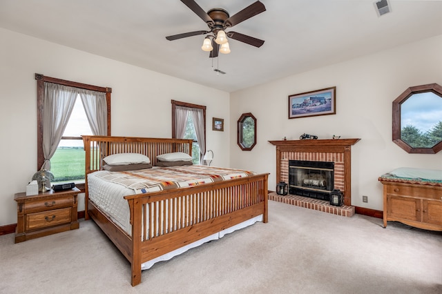 carpeted bedroom with a fireplace and ceiling fan