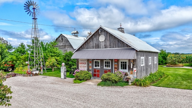 view of front of property with an outdoor structure and a front lawn