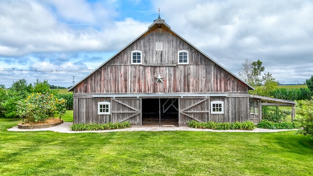 back of property with an outbuilding and a yard