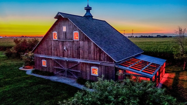 outdoor structure at dusk featuring a yard