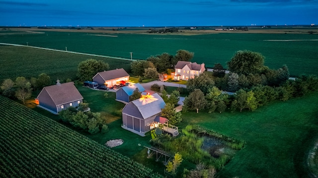 aerial view at dusk with a water view and a rural view