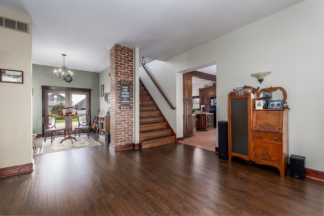 entryway with dark wood-type flooring and a chandelier