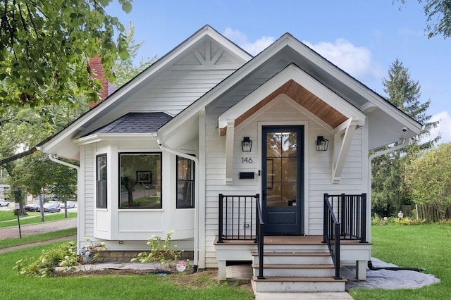 bungalow with a front lawn and covered porch