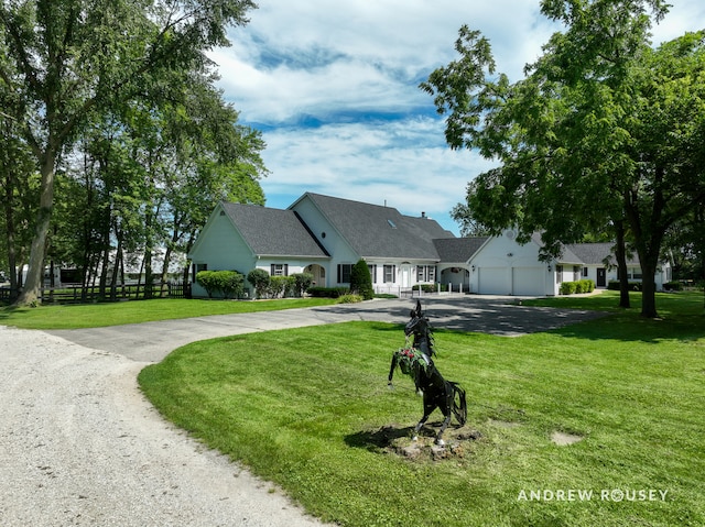 cape cod home with a front yard and a garage