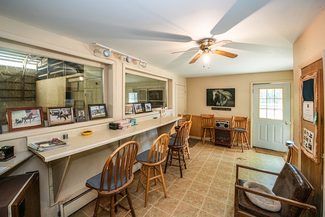 interior space featuring ceiling fan, built in desk, and baseboard heating