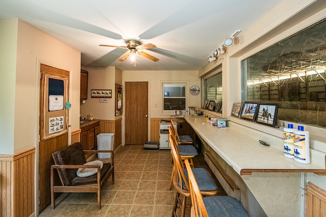 interior space featuring tile patterned flooring, ceiling fan, and kitchen peninsula