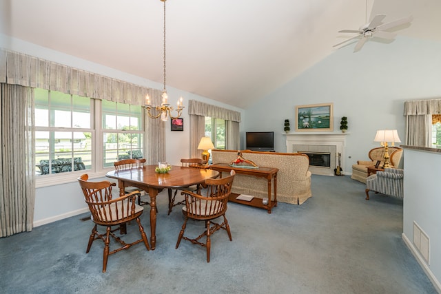 dining area featuring carpet, high vaulted ceiling, ceiling fan with notable chandelier, and a tile fireplace