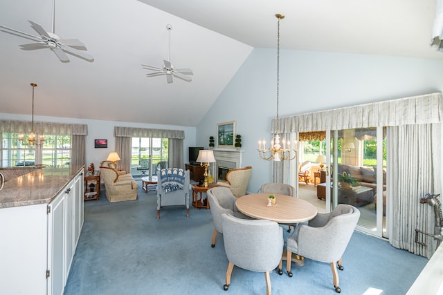 carpeted dining room featuring high vaulted ceiling and ceiling fan with notable chandelier