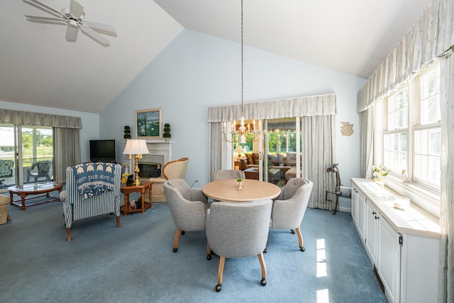 carpeted dining space with high vaulted ceiling and ceiling fan with notable chandelier