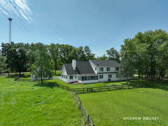 rear view of property featuring a lawn