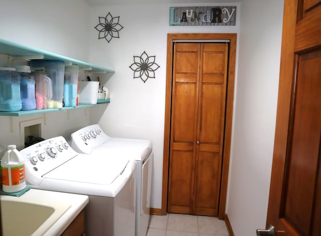 clothes washing area featuring light tile patterned floors, sink, and separate washer and dryer