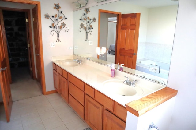 bathroom with tile patterned flooring, a tub to relax in, and vanity