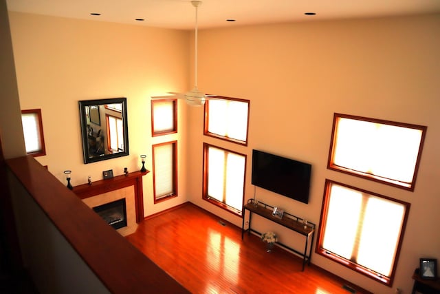 living room with a fireplace, ceiling fan, a healthy amount of sunlight, and hardwood / wood-style floors