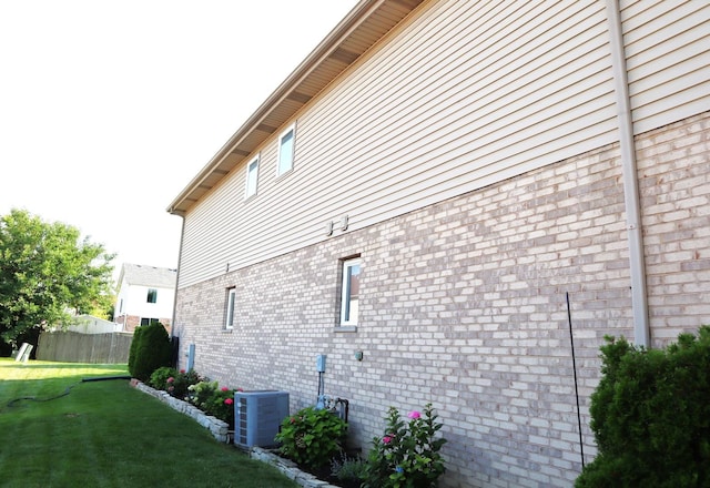 view of home's exterior featuring central AC unit and a yard