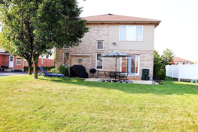 back of house with a patio area and a yard