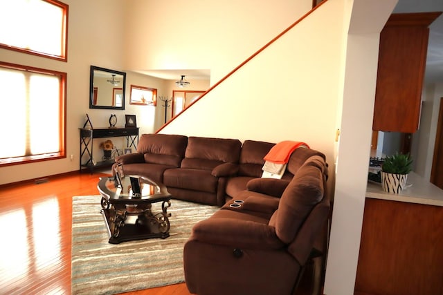 living room with a high ceiling and light hardwood / wood-style floors