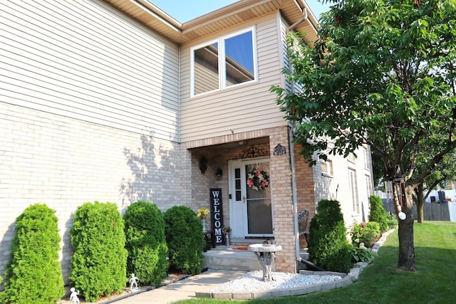 view of exterior entry featuring a yard