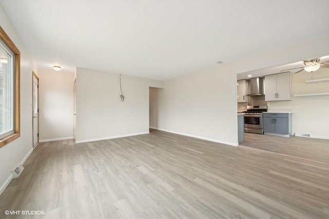 unfurnished living room featuring ceiling fan and light hardwood / wood-style flooring