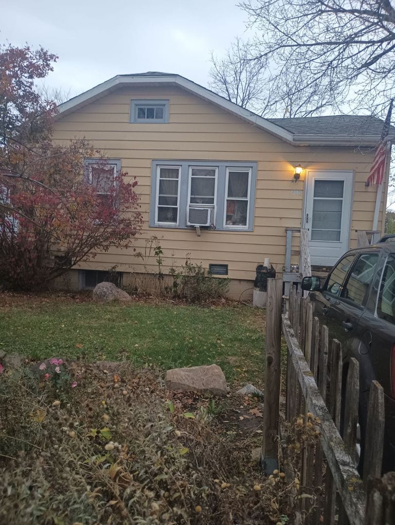 view of side of home with cooling unit and a lawn