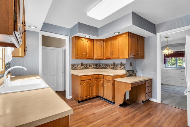 kitchen featuring light hardwood / wood-style flooring, hanging light fixtures, and sink