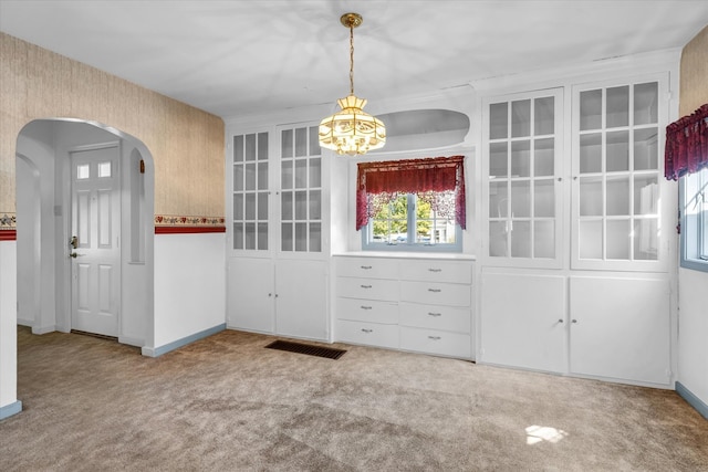 unfurnished dining area featuring light colored carpet