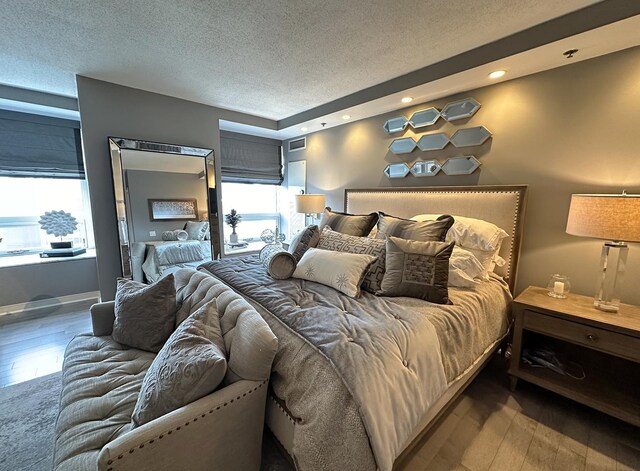 bedroom with a textured ceiling and dark hardwood / wood-style floors