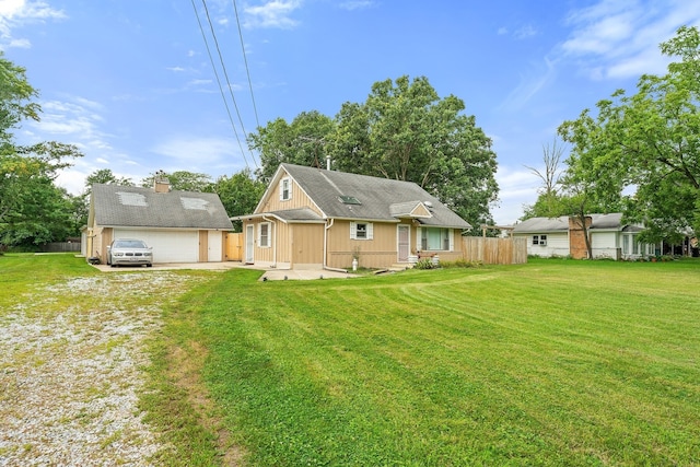 rear view of house featuring a garage and a yard