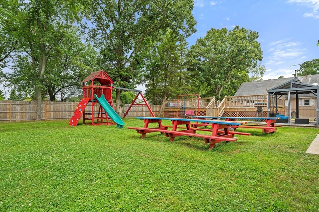 wooden deck featuring a playground, a swimming pool, and a lawn